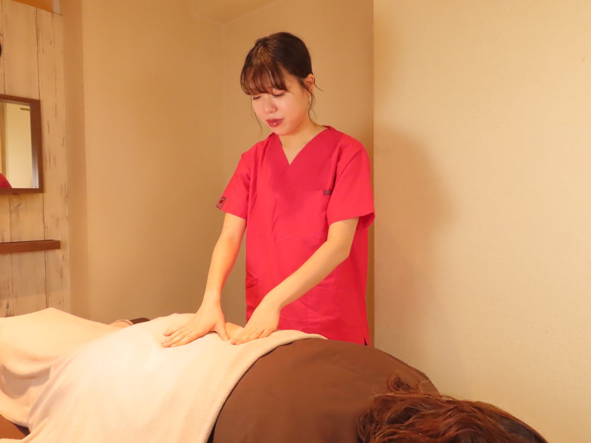 おなかにやさしく手を当てる施術(サクラダ治療室)